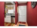 Cozy kitchen view featuring white cabinets and stainless steel appliances near the entry at 400 El Camino Dr # 201, Winter Haven, FL 33884