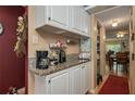 Functional kitchenette area with cabinets and granite countertops by the dining room at 400 El Camino Dr # 201, Winter Haven, FL 33884