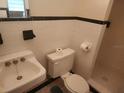 Modest bathroom featuring tiled walls, sink and toilet at 4160 Poinciana Dr, Indian Lake Estates, FL 33855