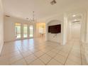 Bright living room features tile floors, high ceilings, and elegant chandelier at 4469 Turnberry Ln, Lake Wales, FL 33859