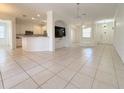 Spacious living room showcasing tile flooring, a kitchen bar and modern design at 4469 Turnberry Ln, Lake Wales, FL 33859
