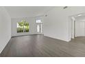 Open-concept living room with vaulted ceiling, wood floors, lots of natural light, and freshly painted walls at 529 Terranova Cir, Winter Haven, FL 33884
