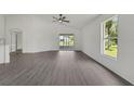 Well-lit living room featuring wood floors, a ceiling fan, sliding glass doors and a large window at 529 Terranova Cir, Winter Haven, FL 33884