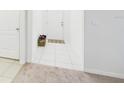 Clean foyer with white walls, tile floors, and a decorative rug near the front door at 5751 Lakeside Landings Blvd, Winter Haven, FL 33881