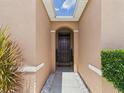Charming front entryway with a dark wood door, decorative plants, and a well-lit porch at 5751 Lakeside Landings Blvd, Winter Haven, FL 33881