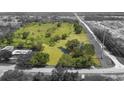 Expansive aerial view showcases the large lot with a creek, mature trees, and a home at 5820 E Johnson Ave, Haines City, FL 33844