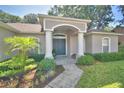Inviting home entrance with a covered porch, decorative columns, and manicured landscaping at 6028 Hillside Heights Dr, Lakeland, FL 33812