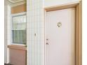 Apartment entrance featuring a pink door, with a window at 700 Mirror Nw Ter # 702, Winter Haven, FL 33881