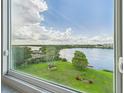 Stunning lake views seen from a large window showcasing the outdoor scenery at 700 Mirror Nw Ter # 702, Winter Haven, FL 33881