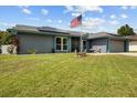 Landscaped front yard featuring a flagpole, walkway, and well-maintained lawn at 704 Butternut Pl, Lakeland, FL 33813