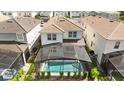 Back aerial view of the home showcasing a screened-in pool and well-manicured backyard at 7247 Oakmoss Loop, Davenport, FL 33837