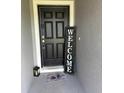 Close-up of the front door features a Welcome mat and sign, enhancing the home's entryway appeal at 737 Daphne Dr, Polk City, FL 33868
