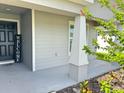 Inviting front porch features a welcome sign and a view of the attractive landscaping and home's facade at 737 Daphne Dr, Polk City, FL 33868