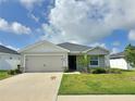 Charming single-story home featuring a well-maintained lawn and an attached two-car garage at 737 Daphne Dr, Polk City, FL 33868