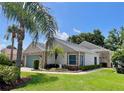 Beautifully landscaped single-story home featuring tropical palm trees at 741 Canberra Rd, Winter Haven, FL 33884