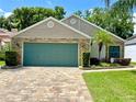 Single-story home featuring a stone accent wall and two-car garage at 741 Canberra Rd, Winter Haven, FL 33884