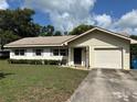 Charming single-Gathering home with a well-maintained lawn, shutters, and attached one car garage at 816 Casselberry Dr, Lake Wales, FL 33853
