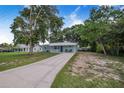 Beautiful single-story home with a long driveway, a covered front porch, and mature trees at 124 Tyler St, Lake Wales, FL 33859