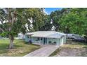 Inviting single-story home with a cozy front porch, well-manicured lawn and a metal roof at 124 Tyler St, Lake Wales, FL 33859
