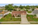 Aerial view of single-story home with well-manicured lawn and two car garage at 1366 Merrimack Pl, Davenport, FL 33837