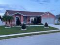 Attractive single-Gathering residence showcasing a tidy front yard, decorative shrubbery and a two-car garage at 1366 Merrimack Pl, Davenport, FL 33837
