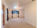 Cozy living room with neutral carpet, a ceiling fan, and a window with decorative curtains at 2125 Hillcrest Rd, Auburndale, FL 33823