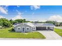 Inviting single-story home featuring gray siding, solar panels, metal roof and large carport at 2218 Melbourne Ave, Haines City, FL 33844