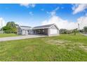 The home features gray siding, a metal roof, solar panels, and a spacious carport area at 2218 Melbourne Ave, Haines City, FL 33844