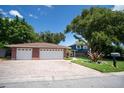 A beautiful home features a two-car garage and a front lawn, on a sunny day at 237 Manatee Rd, Winter Haven, FL 33884