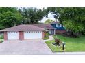 Charming two-story home with brick accents, a spacious three-car garage, and a well-manicured front lawn at 237 Manatee Rd, Winter Haven, FL 33884