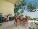 Covered patio with an outdoor dining table, grill, and a clean white fence for privacy at 2538 Crown Ridge Cir, Kissimmee, FL 34744