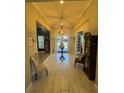 Inviting foyer boasting a high ceiling, decorative light fixture, neutral tones and tile flooring at 25863 Crossings Bluff Ln, Sorrento, FL 32776