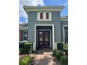 An inviting entryway is highlighted by a double door entry, beautiful landscaping, and textured exterior walls at 25863 Crossings Bluff Ln, Sorrento, FL 32776