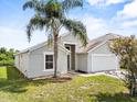 Charming single-story home featuring a well-maintained lawn, mature palm tree, and attached two-car garage at 2740 Rochelle Dr, Winter Haven, FL 33881