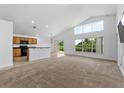 Bright and spacious living room featuring vaulted ceilings, large windows, and a seamless flow to the kitchen at 2740 Rochelle Dr, Winter Haven, FL 33881