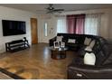 Spacious living room with tile flooring, modern ceiling fan, and a comfortable, oversized sectional sofa at 2800 Sunset Nw Dr, Winter Haven, FL 33881
