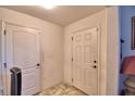 Hallway featuring neutral walls, marble flooring, and two white paneled doors at 286 Cove At Eagle Lake Cir, Eagle Lake, FL 33839