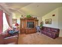 Cozy living room with plush carpeting, a vaulted ceiling and a large entertainment center at 286 Cove At Eagle Lake Cir, Eagle Lake, FL 33839