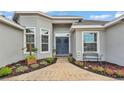 Inviting front entrance with gray stucco, decorative plantings and wreaths on the double-door entry at 308 Kissengen Park Dr, Bartow, FL 33830