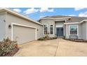 Home featuring a gray exterior, lovely front yard landscaping, a two-car garage, and a gray roof at 308 Kissengen Park Dr, Bartow, FL 33830