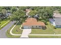 High angle of home with mature shade trees showing a manicured lawn and driveway at 3717 Tigereye Ct, Mulberry, FL 33860