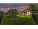 Expansive fenced backyard, features lush lawn and mature trees, providing a serene and private outdoor space at 3717 Tigereye Ct, Mulberry, FL 33860