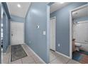 Inviting entryway featuring tile flooring, fresh paint, and access to bathroom at 419 Wellesly Dr, Davenport, FL 33897