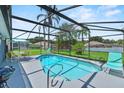Screened-in pool area with outdoor seating and lush landscaping for relaxing at 419 Wellesly Dr, Davenport, FL 33897