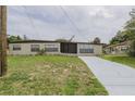 Charming one-story home featuring a newly painted driveway and lush green lawn at 455 Manor Dr, Bartow, FL 33830