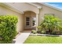 The front entrance is showcased with an arched entry, mature landscaping, and walkway at 464 Lake Suzanne Dr, Lake Wales, FL 33859