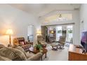 The living room has a vaulted ceiling, fan, and sliding doors to the outdoors with a lake view at 464 Lake Suzanne Dr, Lake Wales, FL 33859