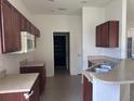 Functional kitchen with dark wood cabinets, laminate countertops, and stainless steel sink at 4747 Mandolin Loop, Winter Haven, FL 33884
