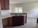 Cozy kitchen area with wooden cabinets, laminate countertops, and view into adjacent living area at 4747 Mandolin Loop, Winter Haven, FL 33884