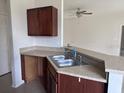 Kitchenette area featuring dark wood cabinets, laminate countertops, and stainless steel sink at 4747 Mandolin Loop, Winter Haven, FL 33884